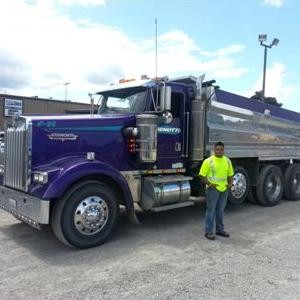 Oscar De Vega Standing Next To One Of The Trucks He Drives For DirTec. He Received His Training From CDS Truck School.
